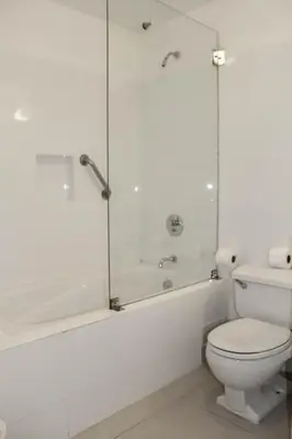 a white bathroom with a toilet and a shower at El Golf Hotel Boutique in Lima