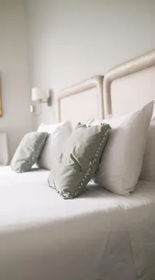 a white bed with four pillows on it at El Golf Hotel Boutique in Lima