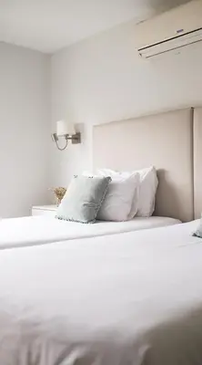 a white bed with white pillows in a bedroom at El Golf Hotel Boutique in Lima