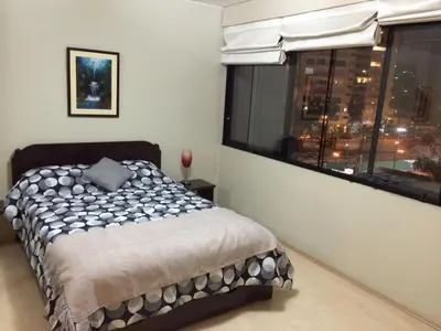 a bedroom with a bed and a large window at Host, Apartment for rent in Lima