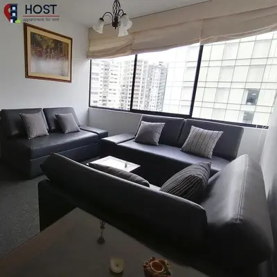 a living room with black couches and a large window at Host, Apartment for rent in Lima