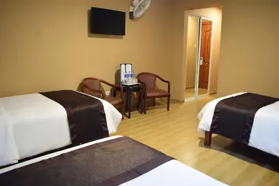 a hotel room with two beds and a table and chairs at Gran Mundo Hotel & Suites in Lima