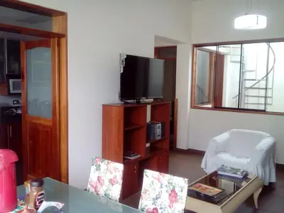 a living room with a tv and a table and chairs at Hospedaje La Anita in Lima