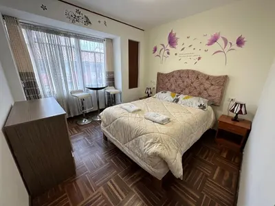 a bedroom with a large bed with flowers on the wall at Euler House`s in Cusco