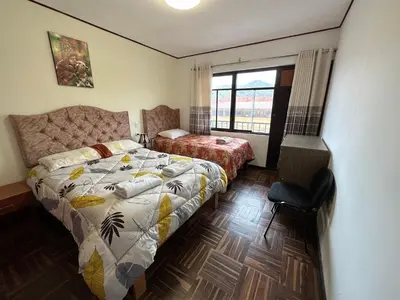 a bedroom with a bed and a desk and a window at Euler House`s in Cusco