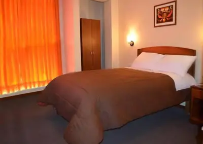 a bedroom with a large bed and a window at Illariy Hotel in Huancavelica
