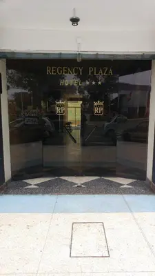 a store front window with the reflection of a hotel at Regency Plaza Hotel in Pisco