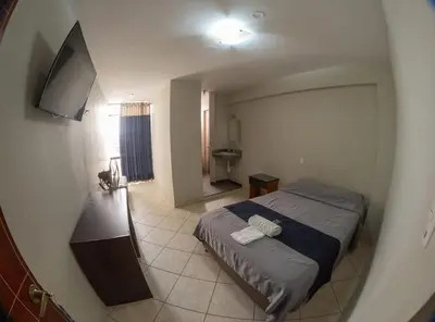 a small bedroom with a bed and a bathroom at Regency Plaza Hotel in Pisco