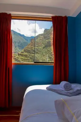 a bedroom with a window with a mountain view at Tumy house B&B in Ollantaytambo