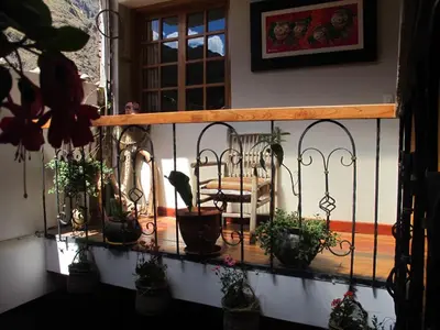 a balcony with a bunch of potted plants on it at Tumy house B&B in Ollantaytambo