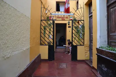 a person sitting in the doorway of a building at Suspiros del Inka in Lima