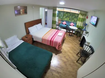 a bedroom with a bed and a table and chairs at Miraflores Departamentos in Lima