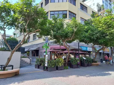 a street with trees in front of a building at Miraflores Departamentos in Lima