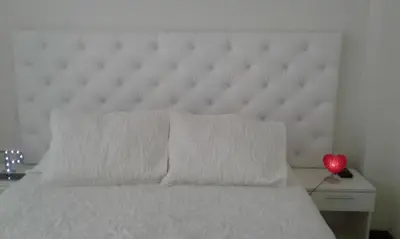 a bed with a white headboard and a red heart on a table at Edificio California en Centro Historico in Lima