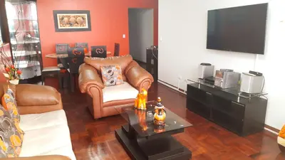 a living room with a leather chair and a television at Apartment Miraflores Pardo in Lima