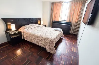 a bedroom with a bed and a wooden floor at Apartment Miraflores Pardo in Lima