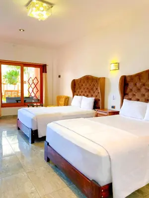 a hotel room with two beds and a window at Hotel Resort Thiago in Chincha Alta