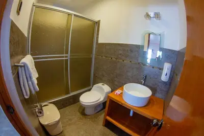 a bathroom with a shower and a toilet and a sink at Hotel Resort Thiago in Chincha Alta