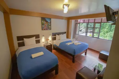 a hotel room with two beds and a window at Samananchis Machupicchu in Machu Picchu