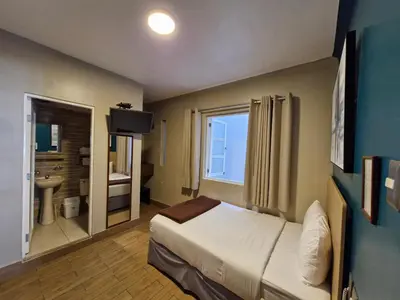 a hotel room with a bed and a bathroom at Residencial Alfa Hotel in Lima