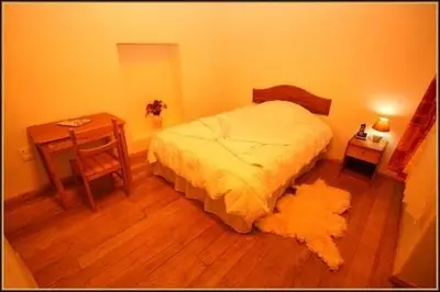 a bedroom with a bed and a table and a desk at Chaquill Chak'a in Cusco