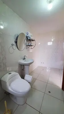 a white bathroom with a toilet and a sink at Hotel Wanka Palace in Huancayo