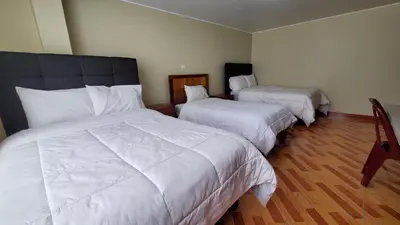 a hotel room with two beds with white sheets at Hotel Wanka Palace in Huancayo