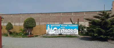 a sign in a parking lot in front of a building at Motel Sahara Suites in Barranca