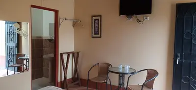 a room with a table and chairs and a television at Motel Sahara Suites in Barranca