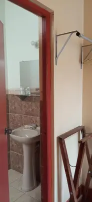 a bathroom with a white sink and a mirror at Motel Sahara Suites in Barranca