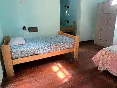 a bedroom with a wooden bed in a room at Wild Olive Guest House in Ica