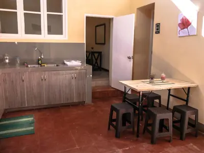 a kitchen with a table and stools in a room at Wild Olive Guest House in Ica