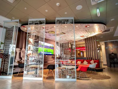 a lobby with a room with chairs and tables at ibis Lima Reducto Miraflores in Lima