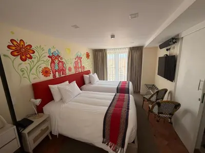 a hotel room with two beds and a painting on the wall at 7 Toritos Hotel Boutique by Hacienda in Cusco