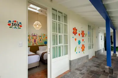 a hallway with a bedroom with a bed and a door at 7 Toritos Hotel Boutique by Hacienda in Cusco