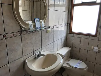a bathroom with a sink and a toilet and a mirror at Hotel de Turistas Abancay in Abancay