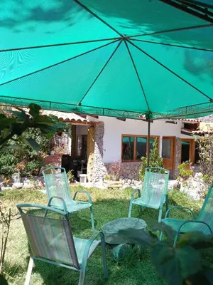 a group of chairs sitting under an umbrella at Casa de Mama Valle - Urubamba in Urubamba