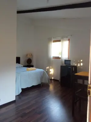 a bedroom with a bed and a wooden floor at Casa de Mama Valle - Urubamba in Urubamba