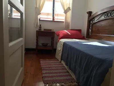 a bedroom with a bed and a window and a rug at Best place in Plaza Mayor Lima, Pizarro building in Lima