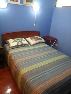 a bedroom with a bed with a blue wall at Hostal Arcangel in Abancay