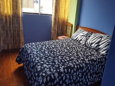 a blue bedroom with a bed and a window at Hostal Arcangel in Abancay