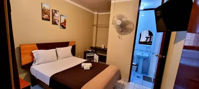 a small bedroom with a bed and a blue door at Starlight Inn in Pisco
