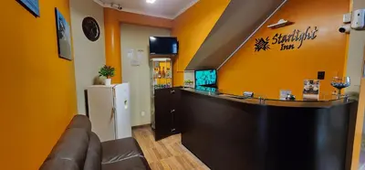 a bar in a restaurant with a counter and a refrigerator at Starlight Inn in Pisco