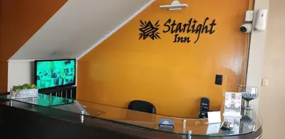 a bar in a hotel room with a sign on the wall at Starlight Inn in Pisco