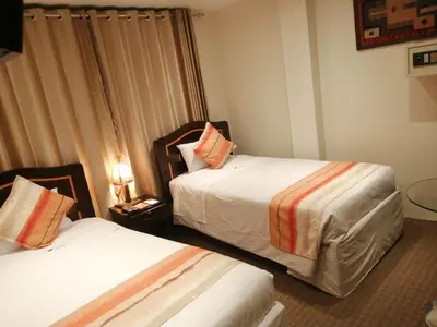a hotel room with two beds and a window at Andino Classic in Machu Picchu
