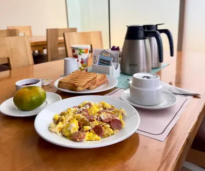 a table with a plate of breakfast food on it at Hotel Asturias Inn in Lima