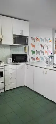a kitchen with white cabinets and animals on the wall at Apartamento Marco Airport in Lima