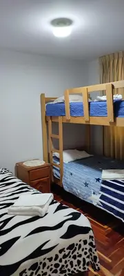 two bunk beds in a room with a zebra print rug at Apartamento Marco Airport in Lima