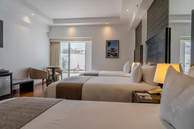 a hotel room with two beds and a desk at Jose Antonio Deluxe in Lima