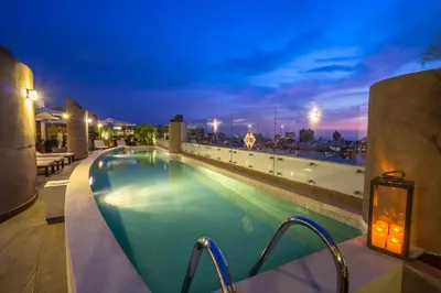 a swimming pool on the roof of a building at night at Jose Antonio Deluxe in Lima